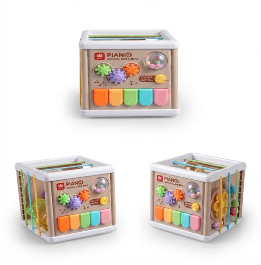 Three views of a wooden activity cubby box toy with colorful piano keys, textured balls, hanging rings, and a peg board, shown on a white background.