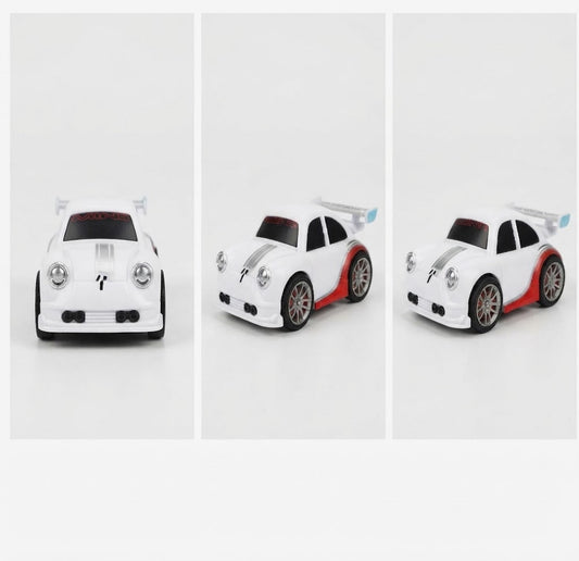 A small white toy sports car shown from three angles in a three-panel layout on a light gray background. The car has red side accents, black wheels, and a small blue accent near the rear spoiler.