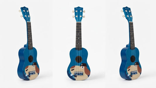 Three views of a blue ukulele with a cartoon dog graphic on the lower bout, shown against a plain white background.