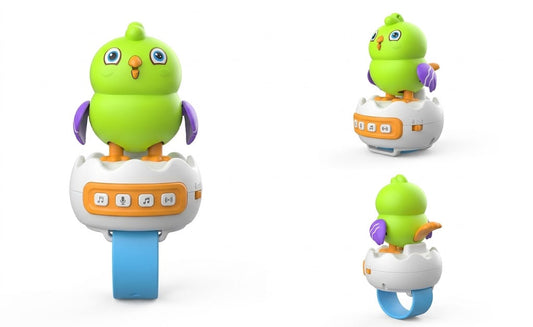 A colorful baby bird toy shown from three angles on a white background. The toy features a bright green bird character with purple wings and an orange beak, sitting on a white egg-shaped base with a blue ring and orange control panel.