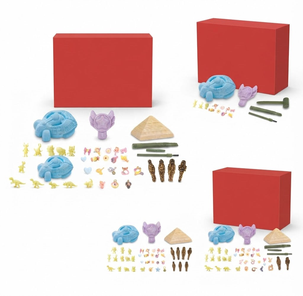 A children's craft kit shown with multiple small craft pieces and two red boxes on a white background. The kit includes blue and purple clay-like pieces, small yellow and pink embellishments, green sticks, brown figurines, and pyramid-shaped pieces.